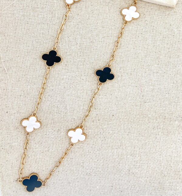 Long gold necklace with black and white clover detail