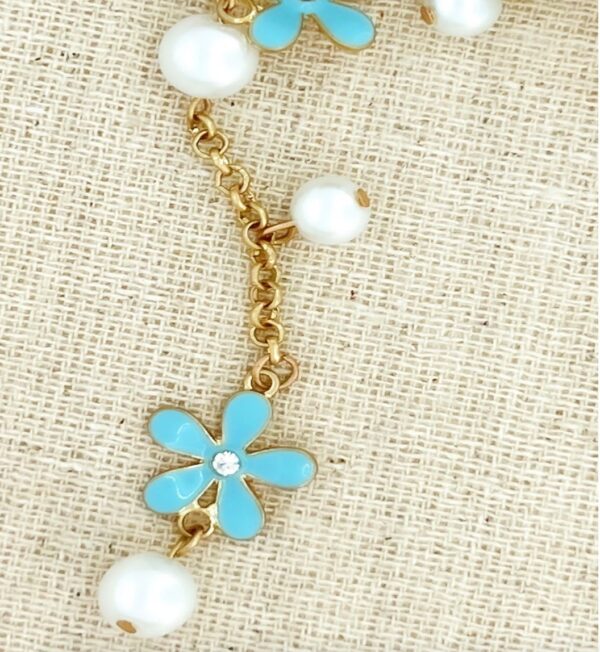 Long gold necklace with blue flowers and pearls